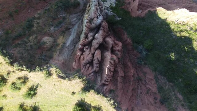 Birds eye view drone shot looking down at an isolated geological rock formation with white spires, heavily texturized mud wrinkles and contrasting shadows in Central Asia, Kazakhstan.
