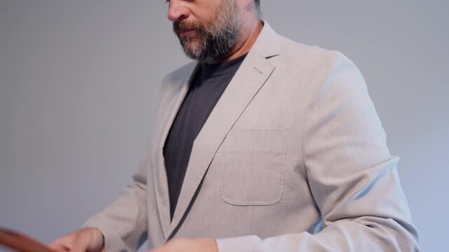 Middle aged candidate anxiously reviews handwritten notes in a leather notebook while waiting for a corporate business job interview in stale office