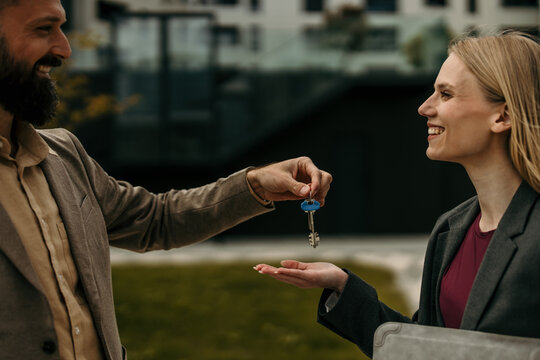 Realtor handing over keys to happy buyer smiling
