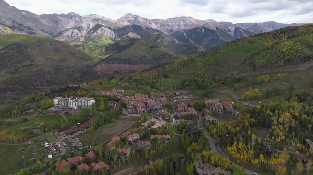 Panoramic aerial view of condos, homes, and golf course in Mountain Village ski town of Telluride, Colorado landscapes with fall foliage during autumn season colors in San Juan Mountains - 4K Drone