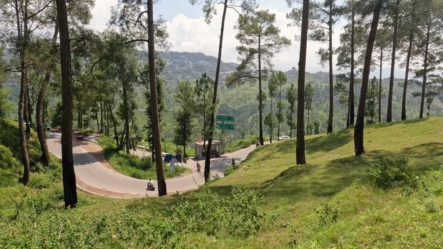 Vehicles Navigating Curvy Himalayan Highway Surrounded By Green Valley