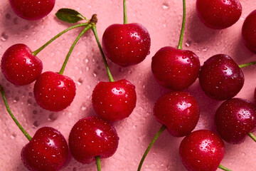 Fresh sweet cherries with water droplets on a pink background © Melica