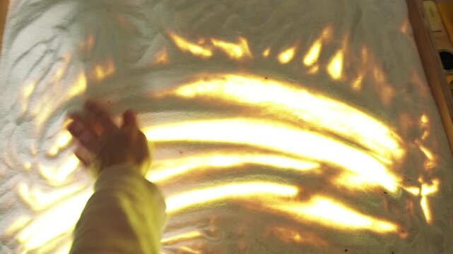 Woman hands drawing on illuminated sand table. Artist creating motion graphic animation with fingers. Fine art creative process light box design craft workshop.