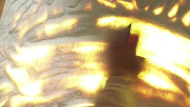 Woman drawing the number fifty in the sand on a backlit table. Creative sand art animation design. Artistic performance with light and shadow for celebration.