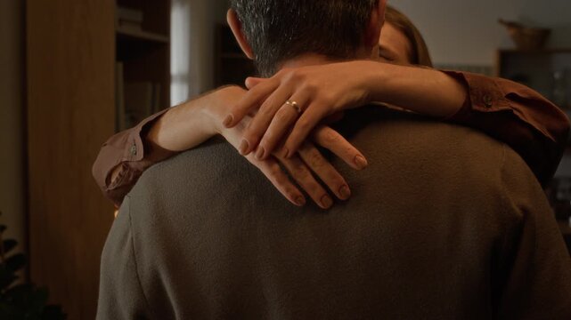 Close up of middle-aged Caucasian couple hugging and slow dancing at home. Footage suitable for family lifestyle commercials, relationship counseling, or financial planning advertisements