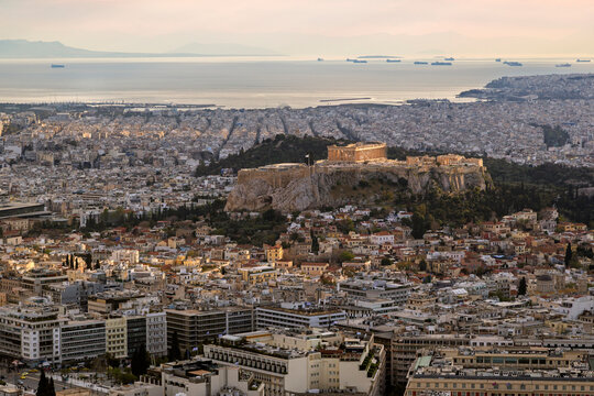 Scenic view of the Parthenon Temple on the Acropolis hill in the downtown of Athens in Greece on a sunny afternoon. Urban skyline, metropolis and city view from above.