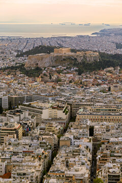 Scenic view of the Parthenon Temple on the Acropolis hill in the downtown of Athens in Greece on a sunny afternoon. Urban skyline, metropolis and city view from above.