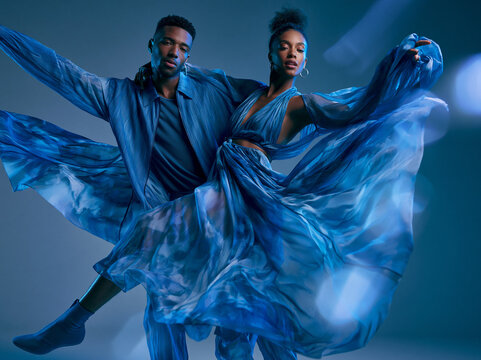 Couple in Blue Flowing Fabrics Against Studio Background