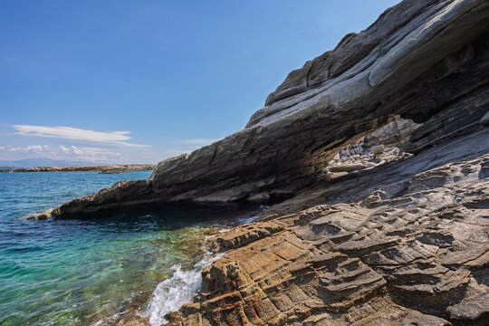 Stunning and big natural arc by the sea at the Paros Park on Paros island in Greece on a sunny day. Rocky geological landscape and natural attraction.