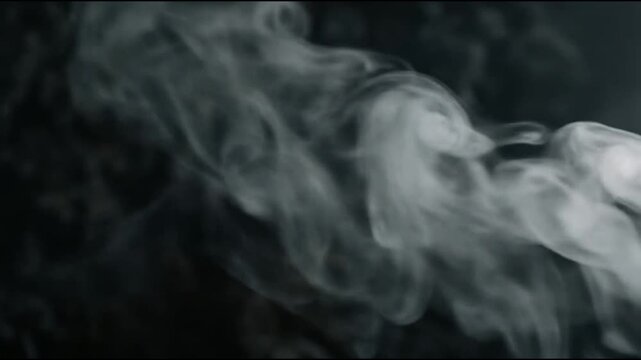 Soft white smoke swirls on a solid black background.