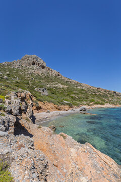 Mountainous, rugged and lush landscape, coastline and the Aegean Sea on Telendos island in Greece on a sunny day.