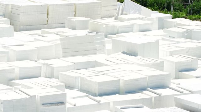 ast organized collection of white rectangular expanded polystyrene foam blocks stacked neatly in rows at an industrial distribution or construction facility