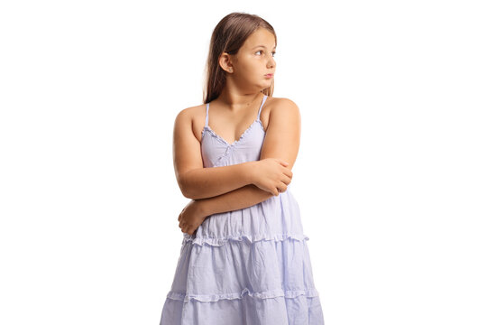 Offended child in a dress standing with arms crossed