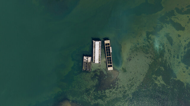 Aerial view of the historic concrete caissons at Inlaag Schelphoek resting in the clear coastal waters of Serooskerke Schouwen, Zeeland, Netherlands.