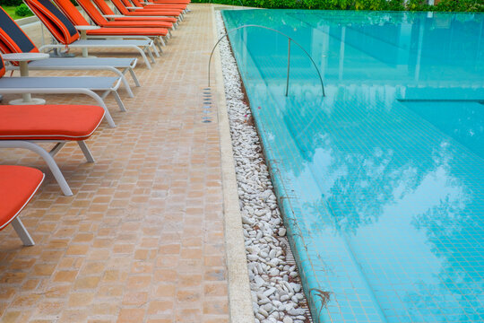 Empty swimming pool with sunbed and white umbrella in resort hotel for vacation leisure and white sand,resort neary sea and beach in summer.
