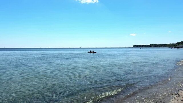 Danish coast with crystal clear water and kayakers.