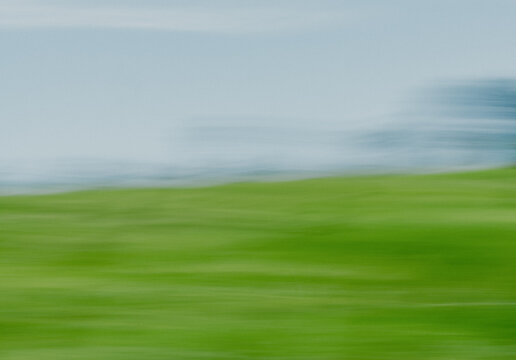 Abstract motion blur of green meadow and pale blue horizon at Enniskillen Conservation Area