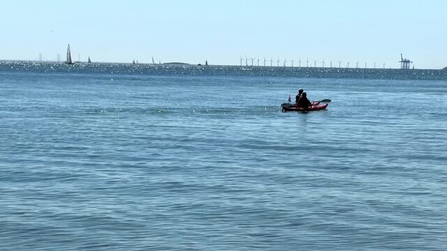 Danish coast with crystal clear water and kayakers.