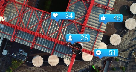 Drone capturing large red steel truss spanning tank farm, showing rising blue icons © vectorfusionart