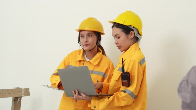 Professional building inspectors or construction engineers are working together, discussing blueprints or project data, engineering teamwork, construction management, safety inspection, site planning.