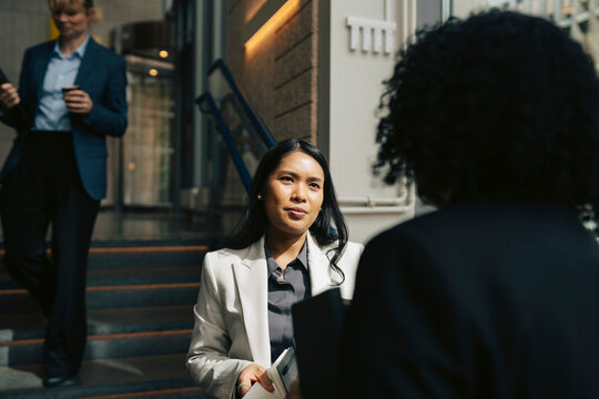 Businesswoman communicating with female entrepreneur at conference event