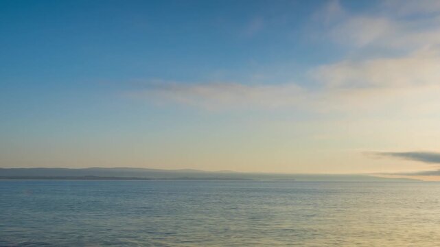 Black Sea and beach nearby against a sky with clouds and a dawn sun