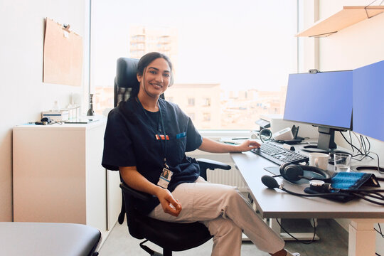 Portrait of confident female doctor sitting on her chair at clinic office
