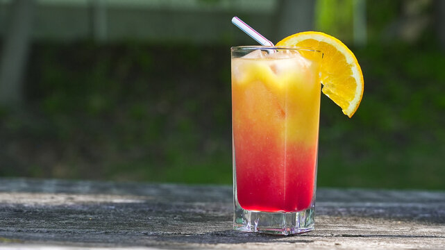 Tequila sunrise cocktail with orange slice and straw