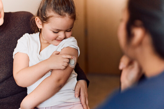 Cute girl showing her continuous glucose monitor to doctor during visit