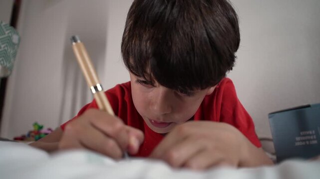 Boy writing at home, highlighting concentration, childhood learning and early education