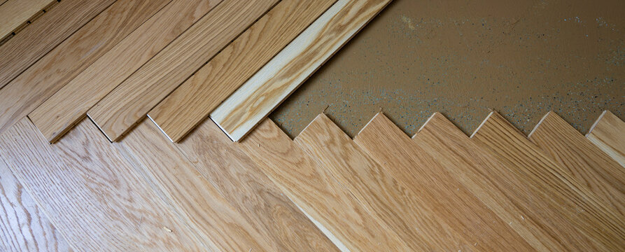 Wide angle view of herringbone parquet installation in modern room
