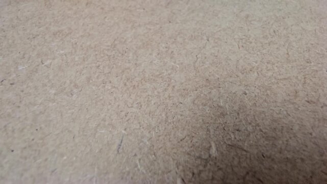 Close-up texture of a brown wooden fiberboard surface