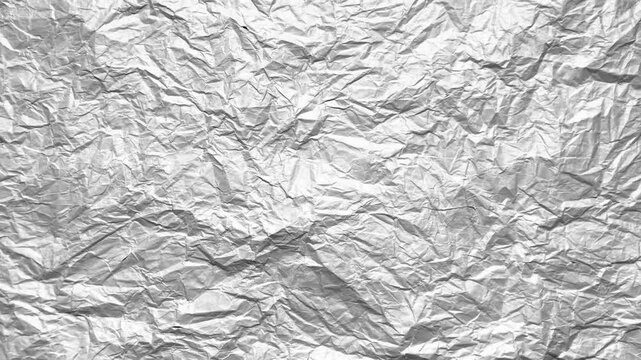 crumpled silver tinfoil texture shimmering under dynamic studio lighting creating abstract metallic pattern