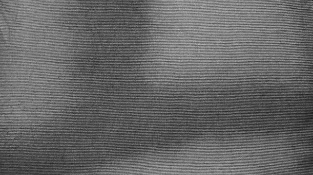 dark grey ribbed cotton fabric macro background showing realistic soft textile texture with organic shadows