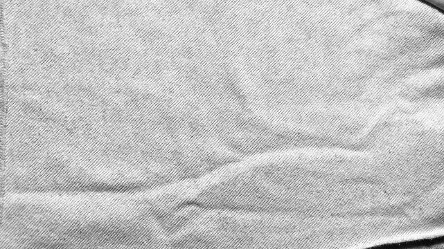 white cotton fabric texture ripples gently under soft cinematic lighting capturing a minimalist sustainable aesthetic