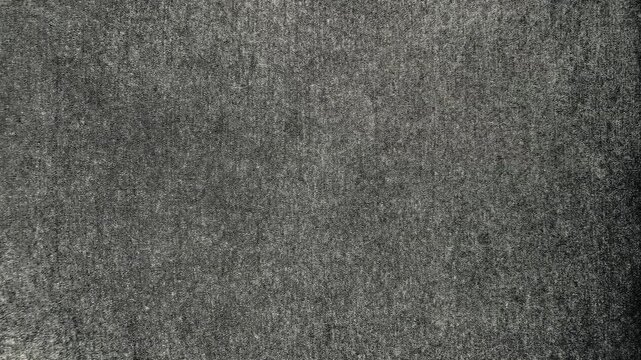 dark grey textured fabric background reveals subtle organic weave under cinematic moody overhead lighting