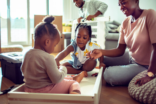 Parents and children assembling furniture at home
