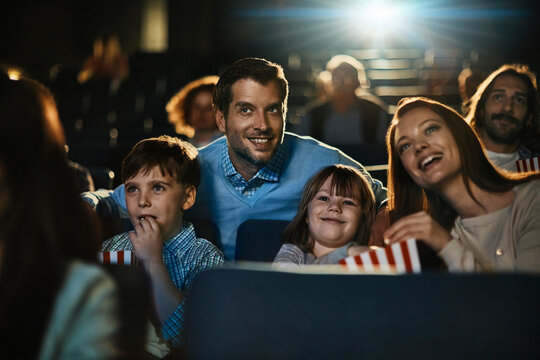Happy family watching a movie together at the cinema