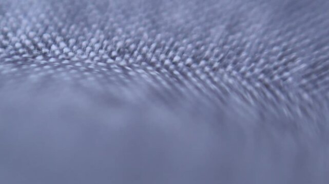 Extreme close-up of interwoven fabric with a focus transition, abstract fabric texture, and selective blur