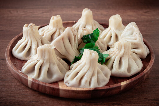 khinkali, on a wooden plate, Georgian traditional dish, on a wooden table, no people,
