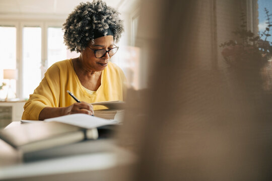 Senior woman spending leisure time studying at retirement home