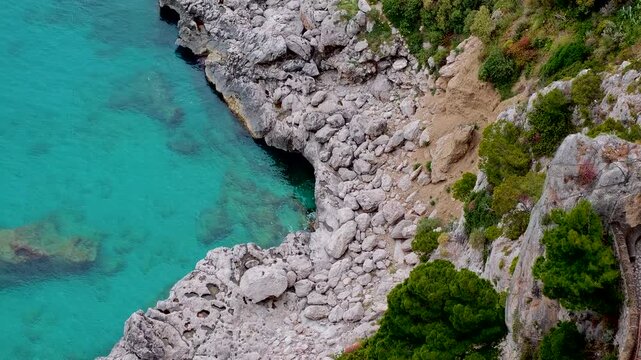 Aerial 4K drone video footage of Via Krupp winding stairs with breathtaking landscape on Capri Island, Italy, dramatic cliffs, turquoise sea and iconic Mediterranean coastal scenery