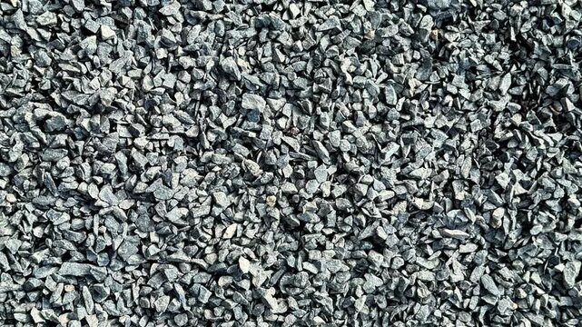 Closeup view of a textured surface of small gray stones with varied shapes and rugged appearance