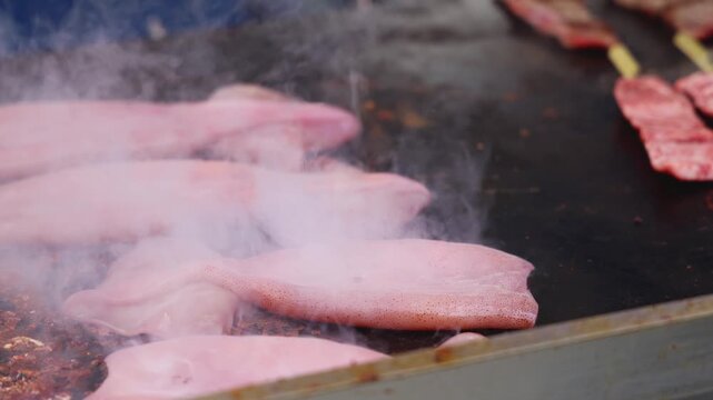Ikayaki, Grilled roasted Squid with sauce - popular Japanese Street Food, variety of different traditional food snack selection in Tokyo, Japan, street market with local vendor stalls cooking