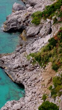 Aerial 4K drone vertical video footage of Via Krupp winding stairs with breathtaking landscape on Capri Island, Italy, dramatic cliffs, turquoise sea and iconic Mediterranean coastal scenery