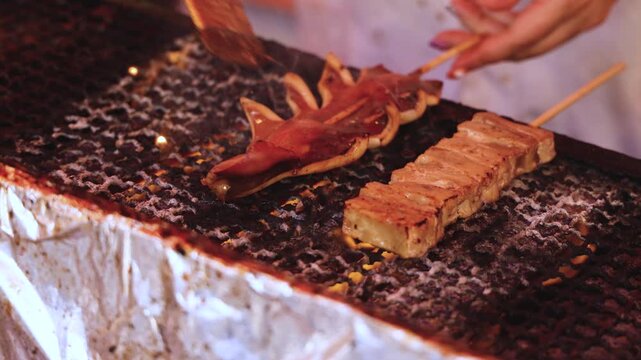 Ikayaki, Grilled roasted Squid with sauce - popular Japanese Street Food, variety of different traditional food snack selection in Tokyo, Japan, street market with local vendor stalls cooking