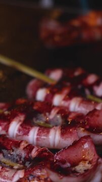 Ikayaki, Grilled roasted Squid with sauce - popular Japanese Street Food, variety of different traditional food snack selection in Tokyo, Japan, street market with local vendor stalls cooking