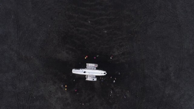 Top down view of plane wreck on black sand