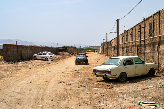 Suburban Dirt Road with Cars and Old Brick Industrial Buildings, Iran
