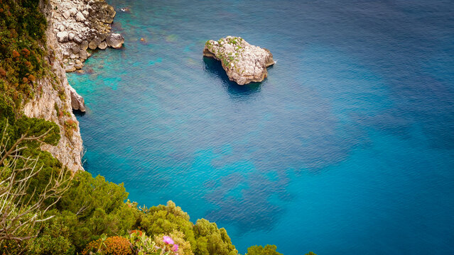 Rocky coastline of Capri Island with crystal-clear turquoise water, breathtaking Mediterranean seascape, dramatic cliffs and pristine coastal landscape in Italy